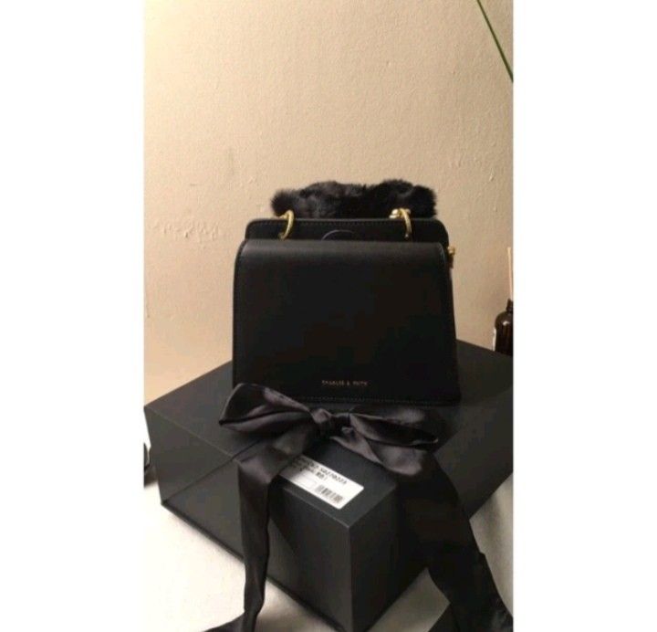 Charles & Keith Black Handbag with Fur Handle (Category: Shoulder Bags) located in Quezon City. Submitted by legitonly420 (Listing ID 1432619357, Image 3). Description: - Charles & Keith black handbag - Features a top handle with fur detailing - Includes a detachable shoulder strap - Adorned with a decorative black ribbon - Rectangular shape - Gold-colored hardware - Comes with original box.