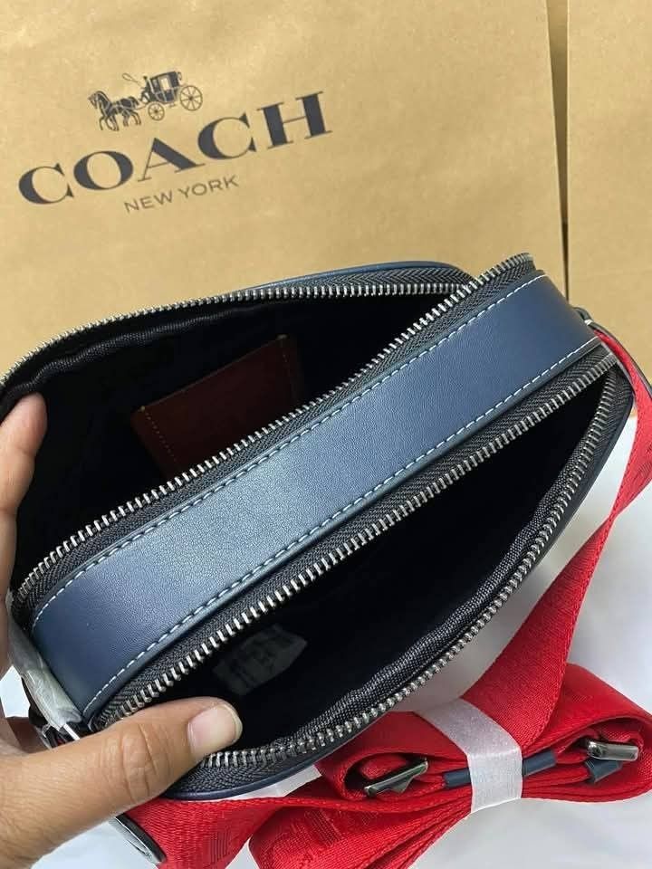 Coach Graham Body Bag (Category: Sling Bags) located in Rizal. Submitted by vanbdc24 (Listing ID 1432710260, Image 2). Description: - Brand new Coach crossbody bag - Navy blue and red stripe design - Zip closure - Adjustable red strap - Coach logo on the front - Spacious interior - Dimensions: 22x14cm - New with tags.