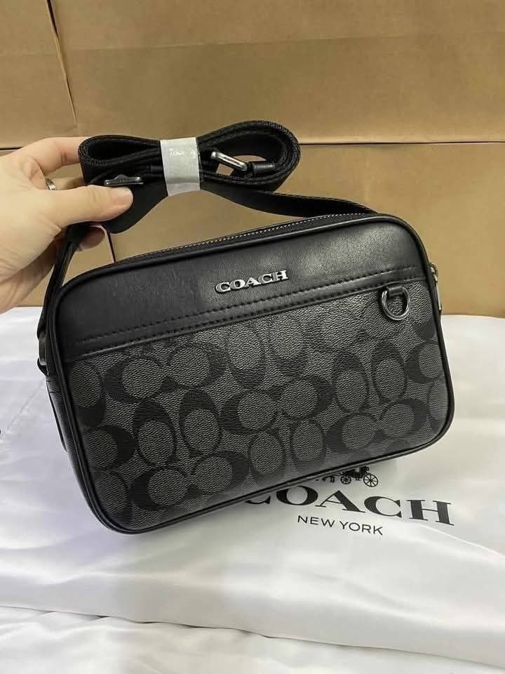 Coach Graham Crossbody Bag (Category: Sling Bags) located in Rizal. Submitted by vanbdc24 (Listing ID 1432709852, Image 1). Description: - Coach men's crossbody bag - Features a stylish black and grey monogram pattern - Secure top zip closure - Adjustable shoulder strap for a comfortable fit - Rectangular shape with Coach logo - Includes an interior pocket - Comes with a Coach dust bag - Dimensions: Approximately 22cm x 15cm.