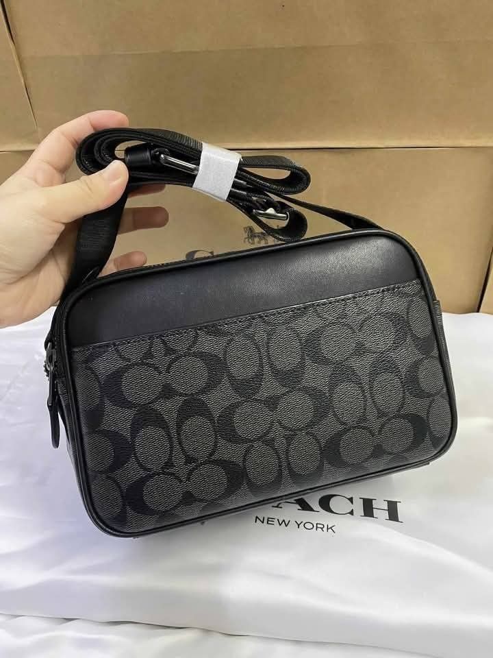 Coach Graham Crossbody Bag (Category: Sling Bags) located in Rizal. Submitted by vanbdc24 (Listing ID 1432709852, Image 2). Description: - Coach men's crossbody bag - Features a stylish black and grey monogram pattern - Secure top zip closure - Adjustable shoulder strap for a comfortable fit - Rectangular shape with Coach logo - Includes an interior pocket - Comes with a Coach dust bag - Dimensions: Approximately 22cm x 15cm.