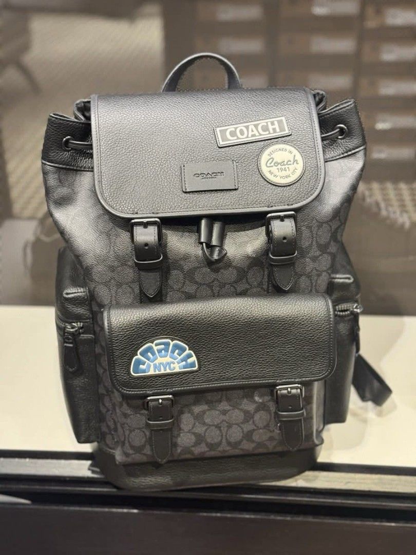 Coach Men's Sprint Backpack (Category: Luxury Bags & Wallets) located in Rizal. Submitted by vanbdc24 (Listing ID 1432716324, Image 1). Description: - Stylish Coach backpack in black. - Features the iconic Coach pattern. - Multiple compartments: front pocket, side pockets, and zippered interior pocket. - Adjustable shoulder straps and top handle. - Includes Coach patches and a 4C patch. - Drawstring closure. - Comes with a Coach hang tag..