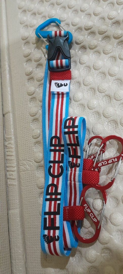 Flip Clip Strap with Carabiners (Category: Hiking & Camping) located in Baguio. Submitted by rozel047 (Listing ID 1432744545, Image 1). Description: - Flip Clip strap - Blue, white, and red striped design - Features a buckle - Includes two red carabiners - 'Flip Clip' brand label - Versatile accessory for various uses.