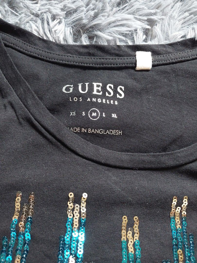 Guess Sequin Embellished Black T-shirt (Category: Shirts) located in Calasiao. Submitted by _annetastic_ (Listing ID 1432637812, Image 2). Description: Sobrang ganda nito in actual 😍 GUESS shirt — bagay sa kahit anong outfit!” “Level up your OOTD 🔥 GUESS shirt na ‘to!” “Low price na for branded 💯 grab niyo na!” - Size: Medium (M) can fit up to semi large kasi strechable .