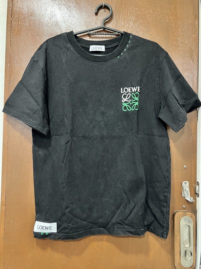 Loewe Black T-shirt (Category: Tshirts & Polo Shirts ) located in Meycauayan. Submitted by 3fold (Listing ID 1432699572, Image 1). Description: - Black Loewe t-shirt - Features the Loewe logo on the front - Additional logo detail at the back of the neck - Crew neck design - Short sleeves - Relaxed fit - Includes a small tag at the bottom.