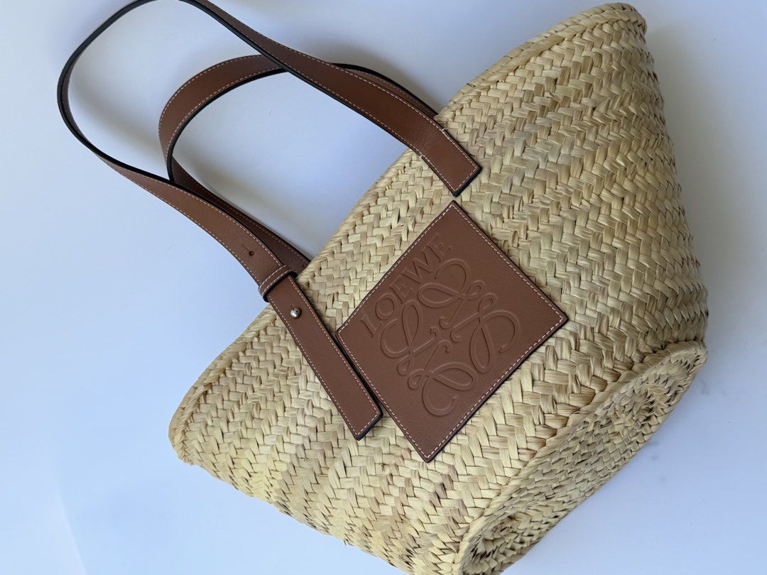 Loewe Raffia Basket Tote Bag Natural Tan AUTHENTIC (Category: Luxury Bags & Wallets) located in Rizal. Submitted by lovelyscloset (Listing ID 1432701096, Image 2). Description: - Authentic Loewe basket bag. - Woven straw body. - Brown leather handles. - Features Loewe logo patch. - Secure leather straps and metal hardware. - Spacious interior. - Ideal for daily use..