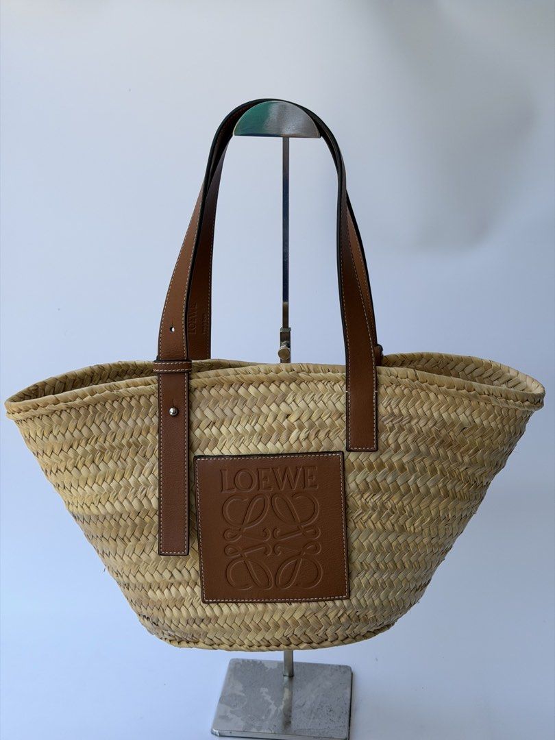 Loewe Raffia Basket Tote Bag Natural Tan AUTHENTIC (Category: Luxury Bags & Wallets) located in Rizal. Submitted by lovelyscloset (Listing ID 1432701096, Image 1). Description: - Authentic Loewe basket bag. - Woven straw body. - Brown leather handles. - Features Loewe logo patch. - Secure leather straps and metal hardware. - Spacious interior. - Ideal for daily use..