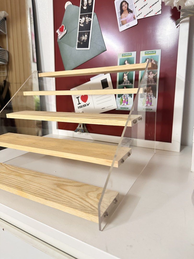 Perfume 5 tier Wooden Display Shelf (Category: Shelves, Cabinets & Racks) located in Quezon City. Submitted by shopsnazzy.mnl (Listing ID 1432626600, Image 2). Description: - Wooden display shelf - Clear acrylic sides - Four tiers - Light-colored wood shelves - Perfect for displaying collectibles, photos, or small items - Great for desks or shelves.