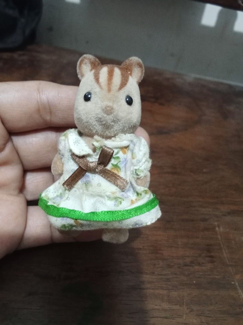 Sylvanian Families Chipmunk Figure (Category: Figurines & Statues) located in Bocaue. Submitted by marajapansurplus (Listing ID 1432639455, Image 2). Description: Adorable Sylvanian Families chipmunk figure is wearing a floral dress with a green trim and a brown bow. It has a fluffy tail and small feet..