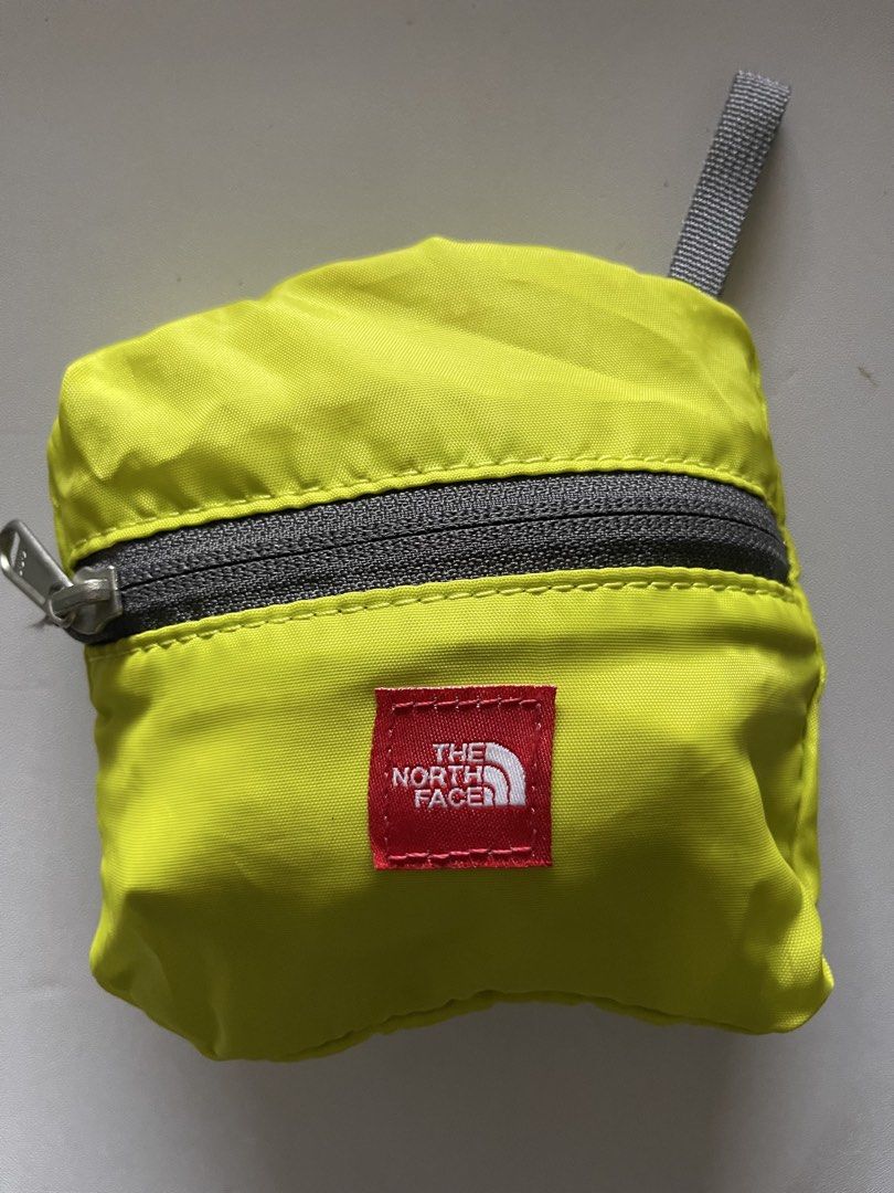 The North Face Packable Shopping Bag Eco Bag (Category: Tote Bags) located in Cavite. Submitted by abellu (Listing ID 1432634136, Image 1). Description: - The North Face shopping bag - Bright yellow color - Folds into a compact pouch - Gray zipper closure - Features a small red brand tag - Includes a carrying loop - Displays brand logo and graphic when unfolded.