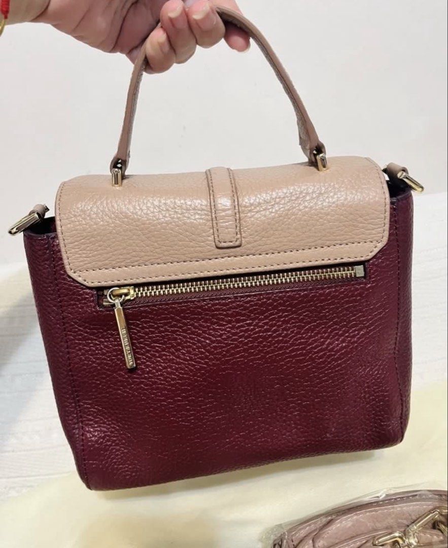 Tory Burch Small Satchel Bag (Category: Luxury Bags & Wallets) located in Quezon City. Submitted by whengaloolu (Listing ID 1432687105, Image 2). Description: - Tory Burch satchel bag - Two-tone design: burgundy body, neutral flap - Detachable shoulder strap - Top handle - Gold-toned logo - Interior zippered pocket - Leather construction.