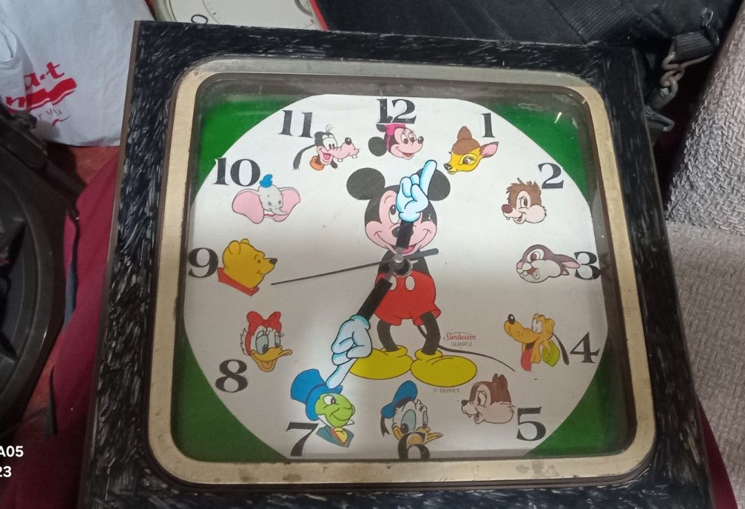 Vintage Disney Mickey Mouse Clock (Category: Clocks) located in Valenzuela. Submitted by consjavier74 (Listing ID 1432693774, Image 1). Description: - Vintage Mickey Mouse Clock - Features Disney characters - Square shape with a black frame - Green border around the clock face - Displays numbers and Disney characters Get it here@Dalandanan,Valenzuela City - Older model, vintage appeal.