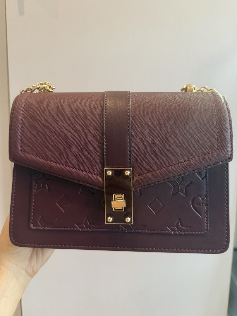 Aldo Burgundy Shoulder Bag with Chain Strap (Category: Shoulder Bags) located in Quezon City. Submitted by delkarl (Listing ID 1432876734, Image 1). Description: - Aldo burgundy shoulder bag - Gold-tone chain strap - Flap closure with gold-tone clasp - Embossed front pattern (hearts, stars, diamonds) - Patterned lining - Interior zippered pocket - Aldo logo on the back.