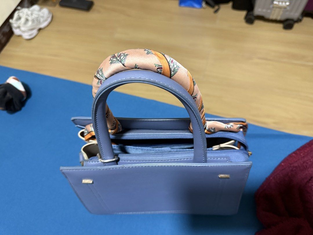 Blue Handbag with Scarf Handle (Category: Shoulder Bags) located in Manila. Submitted by flicker_33 (Listing ID 1432846692, Image 3). Description: - Stylish blue handbag - Decorative scarf on handles - Structured design - Top zipper closure - Gold-colored feet - Includes matching blue shoulder strap - Perfect for everyday or special events.