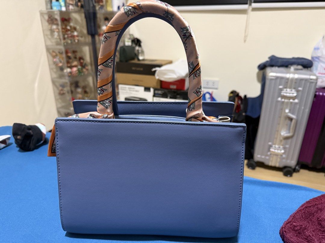 Blue Handbag with Scarf Handle (Category: Shoulder Bags) located in Manila. Submitted by flicker_33 (Listing ID 1432846692, Image 1). Description: - Stylish blue handbag - Decorative scarf on handles - Structured design - Top zipper closure - Gold-colored feet - Includes matching blue shoulder strap - Perfect for everyday or special events.