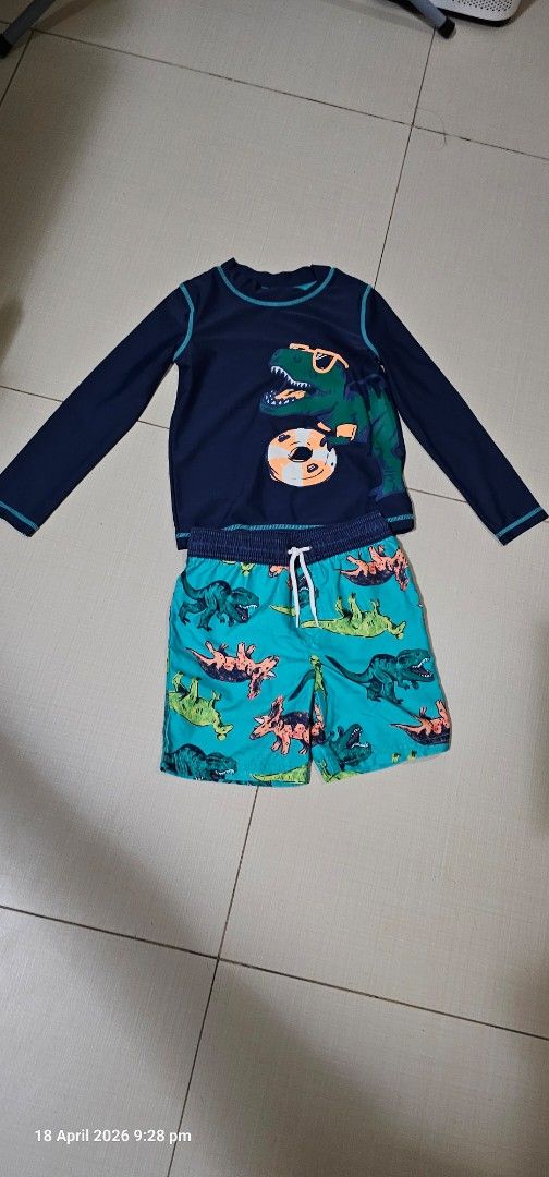 Carter's Dinosaur Swimsuit Set 5T/5A (Category: Babies & Kids Fashion) located in Cebu City. Submitted by everythingonearth (Listing ID 1432937690, Image 1). Description: - Carter's boys' 2-piece swimsuit set - Size: 5T/5A - Features: - Long-sleeved navy top with dinosaur graphic - Matching turquoise shorts with dinosaur print - Made in Cambodia.