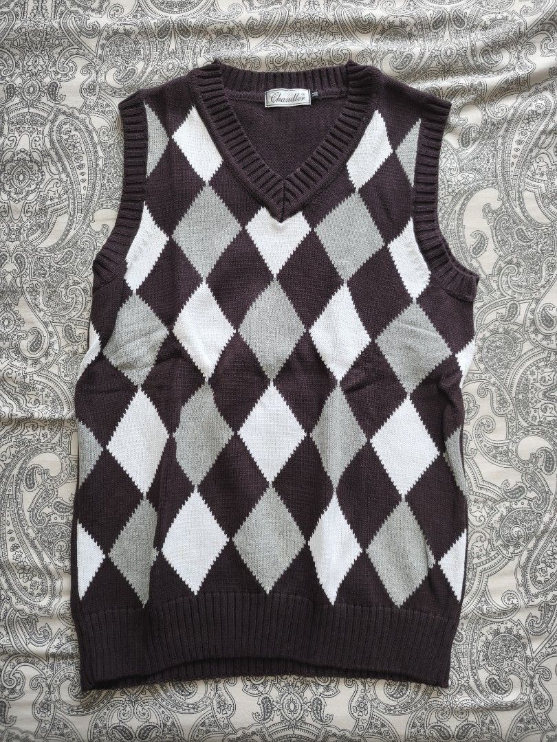 Chandler Argyle V-Neck Vest (Category: Vests) located in Mandaluyong City. Submitted by s0nym (Listing ID 1432846562, Image 1). Description: - Chandler argyle vest - Classic V-neck - Brown, white, and gray diamond pattern - Sleeveless design - Knitted material - Brand: Chandler - Perfect for layering.