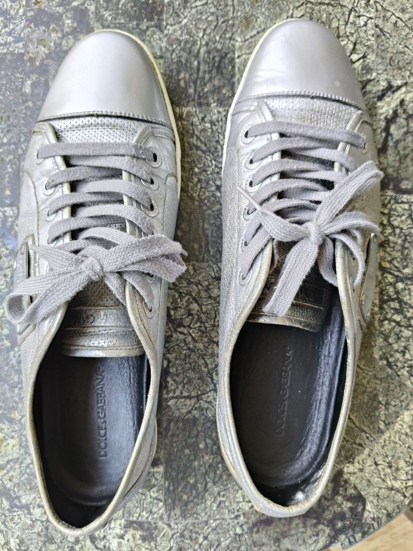 Dolce & Gabbana Sneakers (Category: Sneakers) located in Tagbilaran City. Submitted by johnmcee (Listing ID 1432865986, Image 2). Description: Dolce & Gabbana silver sneakers size on tag 9.5. best fit US9.5-10 - Leather upper - Perforated design on sides - Metal plate on tongue with brand name and "Men's Collection" - Dolce & Gabbana logo on soles - Grey laces - Low-top design issue: one missing screw on the side..