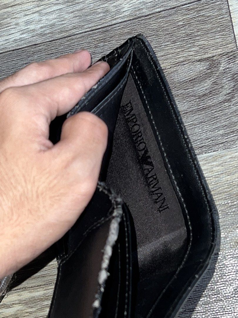 Emporio Armani Black Wallet (Category: Luxury Bags & Wallets) located in Tagum. Submitted by midolli (Listing ID 1432890899, Image 3). Description: - Emporio Armani wallet - Silver logo detail - Multiple card slots - Coin compartment with snap closure - Interior lining shows wear and tear.