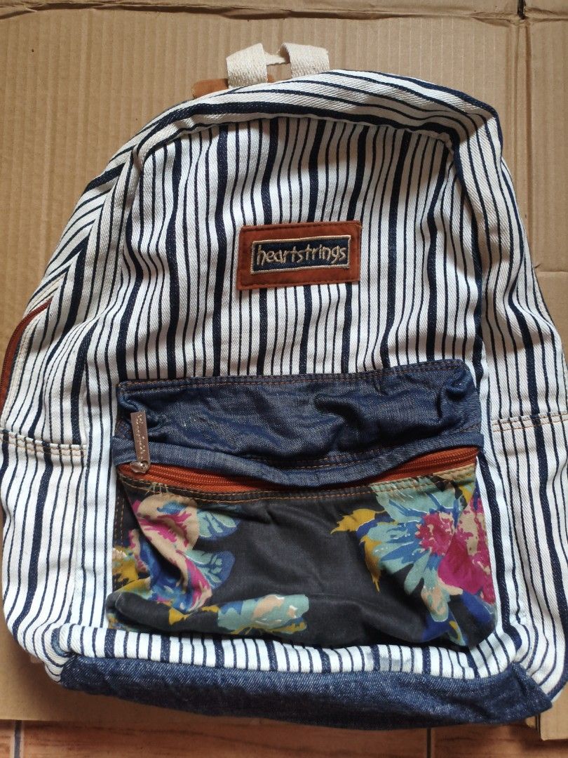 BRAND NEW! Heartstrings Striped Backpack (Category: Backpacks) located in Pasig City. Submitted by coolphoenix-29ac (Listing ID 1432896333, Image 2). Description: - Heartstrings backpack with a unique striped pattern. - Features a denim front pocket and charming floral accents. - Adjustable shoulder straps and a convenient top handle. - Includes a zippered front pocket for easy access. - Spacious main compartment with a neutral fabric lining. - D