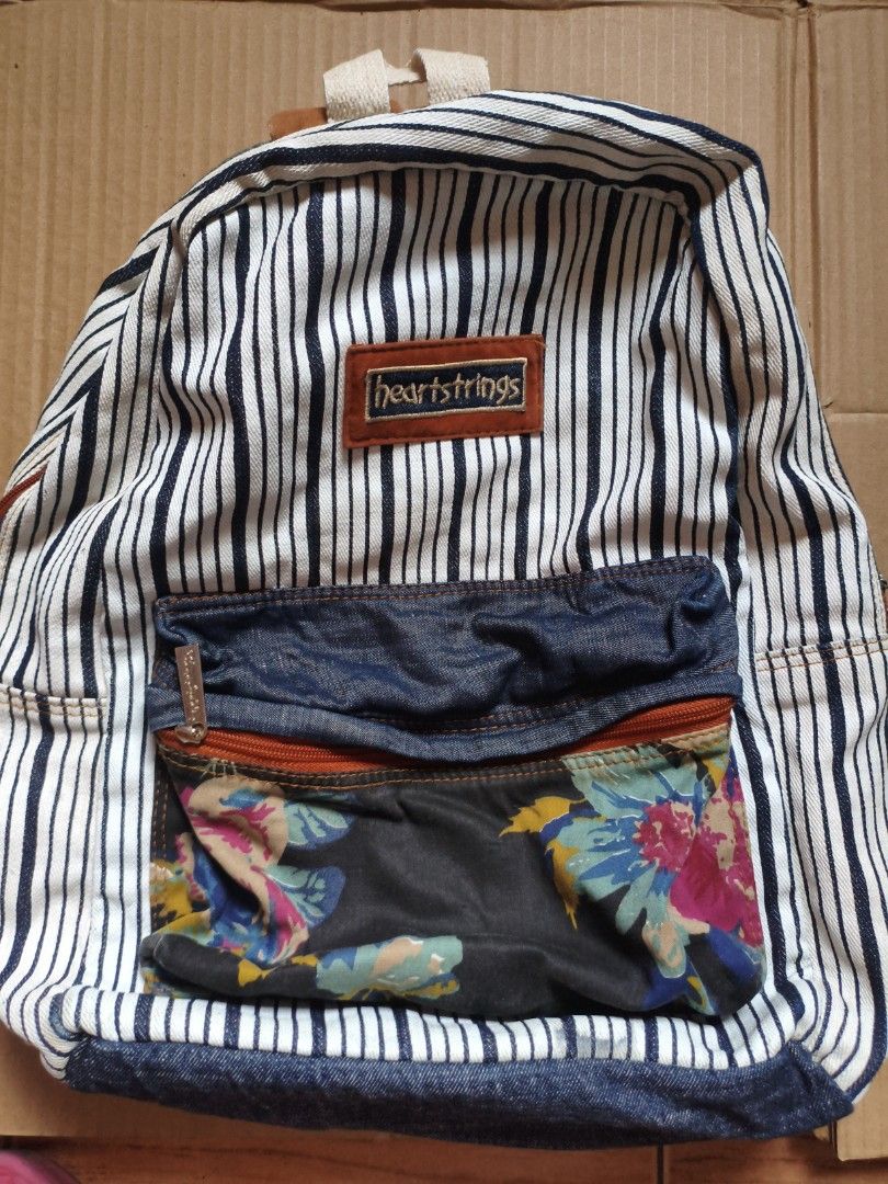 BRAND NEW! Heartstrings Striped Backpack (Category: Backpacks) located in Pasig City. Submitted by coolphoenix-29ac (Listing ID 1432896333, Image 1). Description: - Heartstrings backpack with a unique striped pattern. - Features a denim front pocket and charming floral accents. - Adjustable shoulder straps and a convenient top handle. - Includes a zippered front pocket for easy access. - Spacious main compartment with a neutral fabric lining. - D