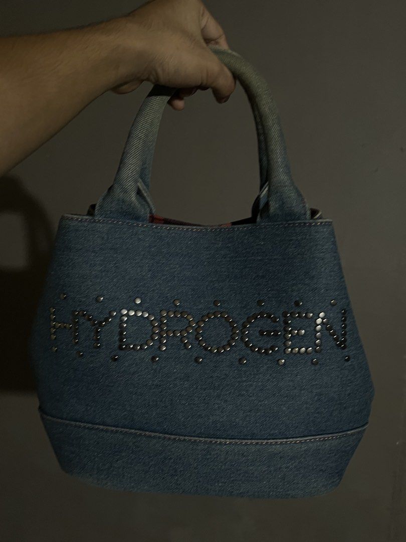 Hydrogen Denim Handbag with Skull Design (Category: Luxury Bags & Wallets) located in Tagum. Submitted by midolli (Listing ID 1432914959, Image 1). Description: - Stylish Hydrogen handbag - Made of denim - Features a skull design with studded details - Red and black plaid interior lining - Includes a zippered pocket - Two handles - Magnetic closure - Brand logo visible inside.