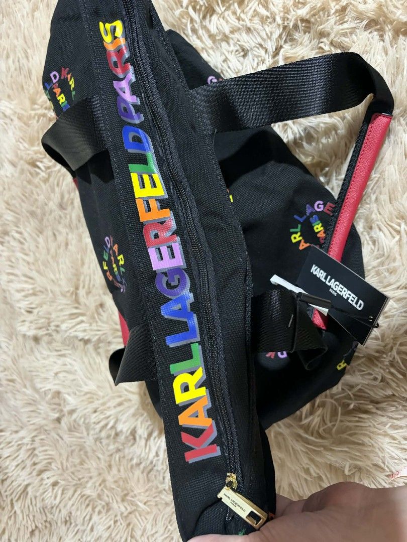 Karl Lagerfeld Paris Tote Bag (Category: Tote Bags) located in Pateros City. Submitted by armcandystuff (Listing ID 1432866436, Image 2). Description: - Karl Lagerfeld Paris tote bag -19" wide x 14" tall - Black base with rainbow circular logo - Zipper closure - Red handles - Rainbow Karl Lagerfeld Paris logo on side - Interior pocket - Includes tag.
