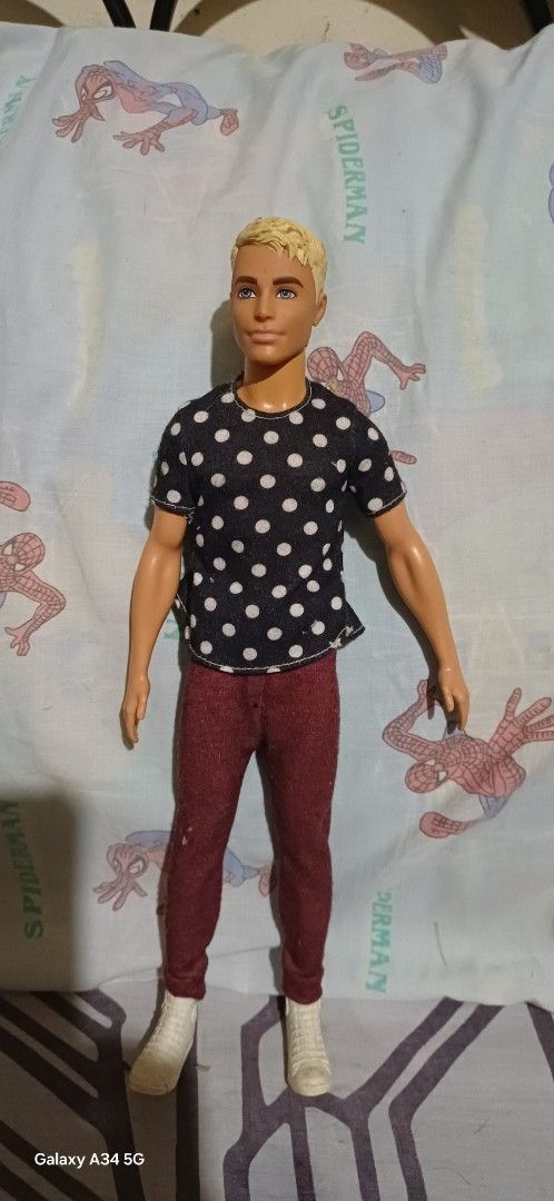 Ken Doll Assortment (Category: Babies & Kids Fashion) located in San Mateo. Submitted by alex1_6 (Listing ID 1432943424, Image 1). Description: - Ken doll collection featuring four unique dolls: - Doll 1: Black polka dot shirt, maroon pants. - Doll 2: Patterned shirt, light blue shorts. - Doll 3: Green top, gray pants, red boots. - Doll 4: Floral shirt, blue pants..