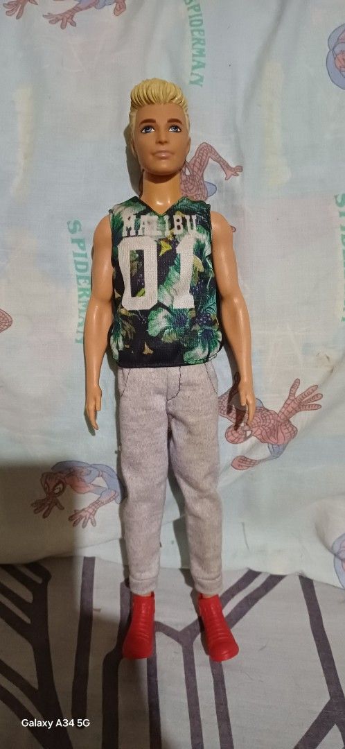 Ken Doll Assortment (Category: Babies & Kids Fashion) located in San Mateo. Submitted by alex1_6 (Listing ID 1432943424, Image 3). Description: - Ken doll collection featuring four unique dolls: - Doll 1: Black polka dot shirt, maroon pants. - Doll 2: Patterned shirt, light blue shorts. - Doll 3: Green top, gray pants, red boots. - Doll 4: Floral shirt, blue pants..