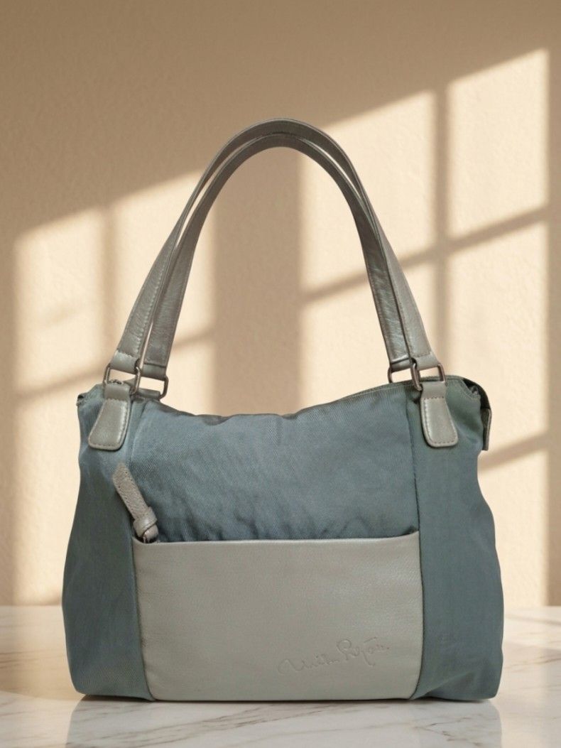 Mila Schon Shoulder Bag (Category: Shoulder Bags) located in Pasay City. Submitted by onick_79 (Listing ID 1432964152, Image 1). Description: - Mila Schon shoulder bag - Elegant blue-grey color - Front pocket for easy access - Spacious interior with multiple compartments - Comfortable shoulder strap - Secure zip closure - Interior pocket with brand label - Stylish silver metallic handles Mila Schön shoulder bag, an Italian luxury brand known for 