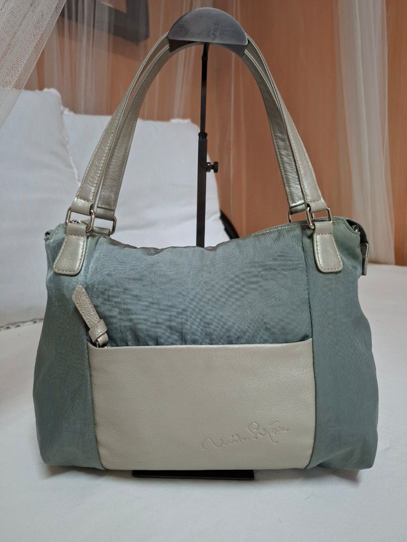 Mila Schon Shoulder Bag (Category: Shoulder Bags) located in Pasay City. Submitted by onick_79 (Listing ID 1432964152, Image 2). Description: - Mila Schon shoulder bag - Elegant blue-grey color - Front pocket for easy access - Spacious interior with multiple compartments - Comfortable shoulder strap - Secure zip closure - Interior pocket with brand label - Stylish silver metallic handles Mila Schön shoulder bag, an Italian luxury brand known for 