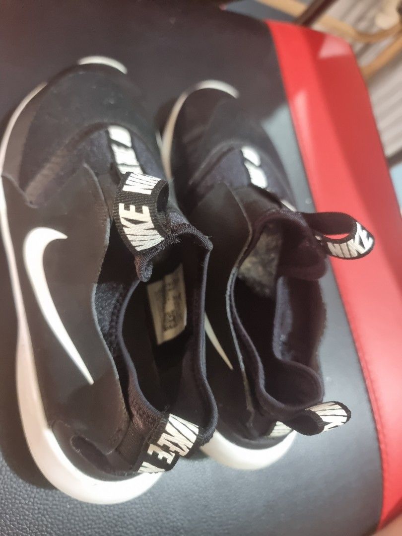 Nike Flex Runner Black US7Youth 25cm (Category: Sneakers) located in Quezon City. Submitted by waemierrie (Listing ID 1432888411, Image 3). Description: Original Nike Flex Runner slip-on shoes in black and white. US7 Youth 25cm signs of usage, wala naman po butas sa body okay din outsole. Features a black upper with a white Nike swoosh and white midsole. The shoes have a slip-on design with a strap that says "NIKE" repeatedly. The size is US 7Y, 