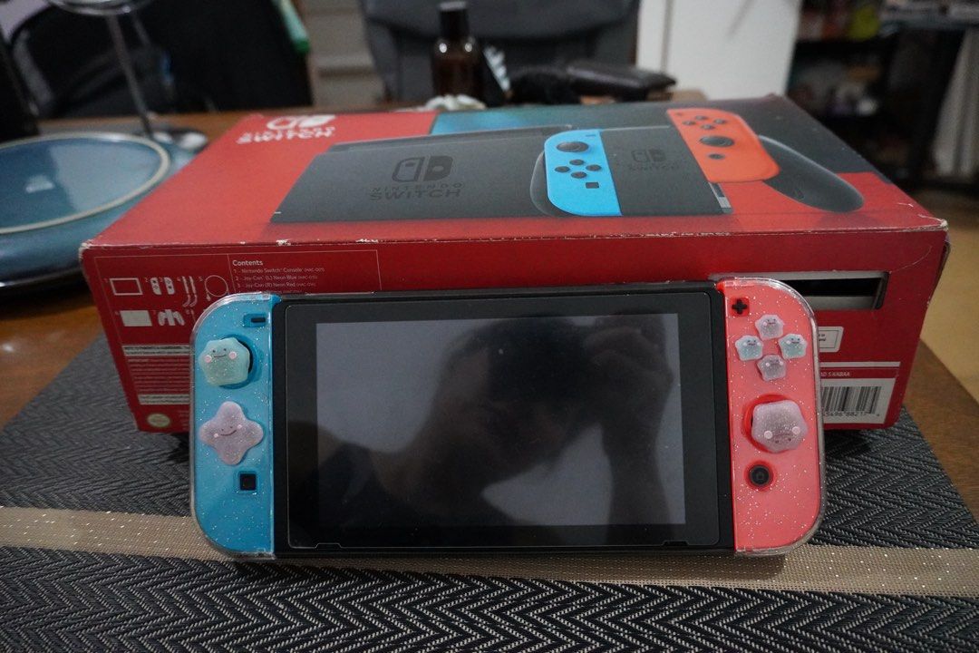Nintendo Switch 1 with free Animal Crossing (Category: Nintendo) located in Quezon City. Submitted by katherine_is_selling (Listing ID 1432934516, Image 1). Description: - Nintendo Switch console with blue and red Joy-Cons - Includes the original box and all original accessories - Comes with a copy of Animal Crossing: New Horizons - Joy-Cons have protective cases - Screen displays the game library - Box contents: Console, Joy-Con controllers, doc