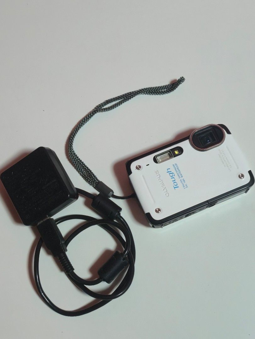 Olympus Stylus Tough TG-625 Digital Camera (Category: Cameras) located in Quezon City. Submitted by marianedb (Listing ID 1432884154, Image 2). Description: - Olympus Stylus Tough TG-625 digital camera - Includes charger - Includes wrist strap - Includes Original Ferrari Carrying case - box - Color: White and Black - Features screen and buttons - Camera labeled "Tough" and "Stylus".