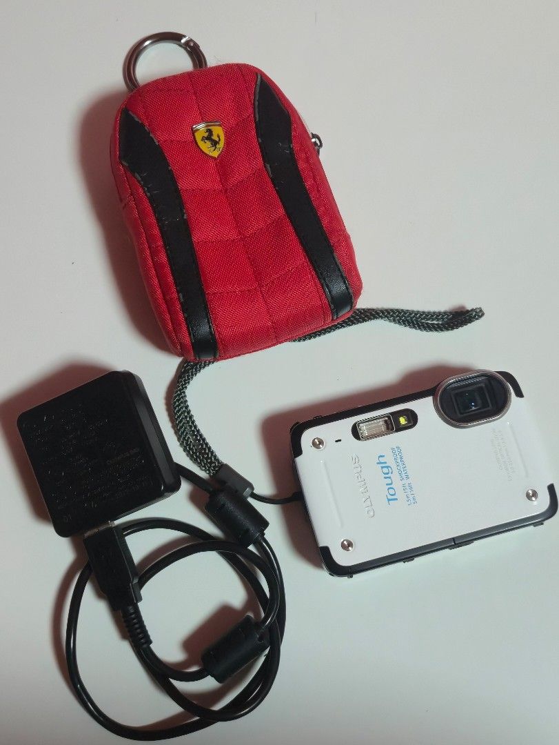Olympus Stylus Tough TG-625 Digital Camera (Category: Cameras) located in Quezon City. Submitted by marianedb (Listing ID 1432884154, Image 1). Description: - Olympus Stylus Tough TG-625 digital camera - Includes charger - Includes wrist strap - Includes Original Ferrari Carrying case - box - Color: White and Black - Features screen and buttons - Camera labeled "Tough" and "Stylus".