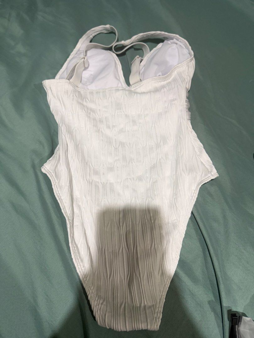 One Piece Strap White Textured Swimsuit (Category: Bikinis & Swimsuits) located in Manila. Submitted by _boxofelle (Listing ID 1397816820, Image 3). Description: - White textured one-piece swimsuit - Features a flattering V-neck - Adjustable straps for a custom fit - Ideal for swimming and beach activities Brand new, never been used Rfs: Not my style.