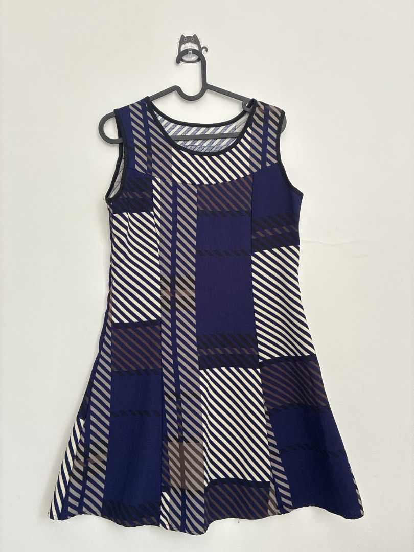 Plaid Sleeveless Dress (Category: Dresses) located in Taguig. Submitted by polengreyn (Listing ID 1432862585, Image 1). Description: - Sleeveless plaid dress - Colors: Blue, white, and brown - Round neckline - Flared skirt - Black trim on neckline and armholes - Minor tear on side seam - Includes hanger.