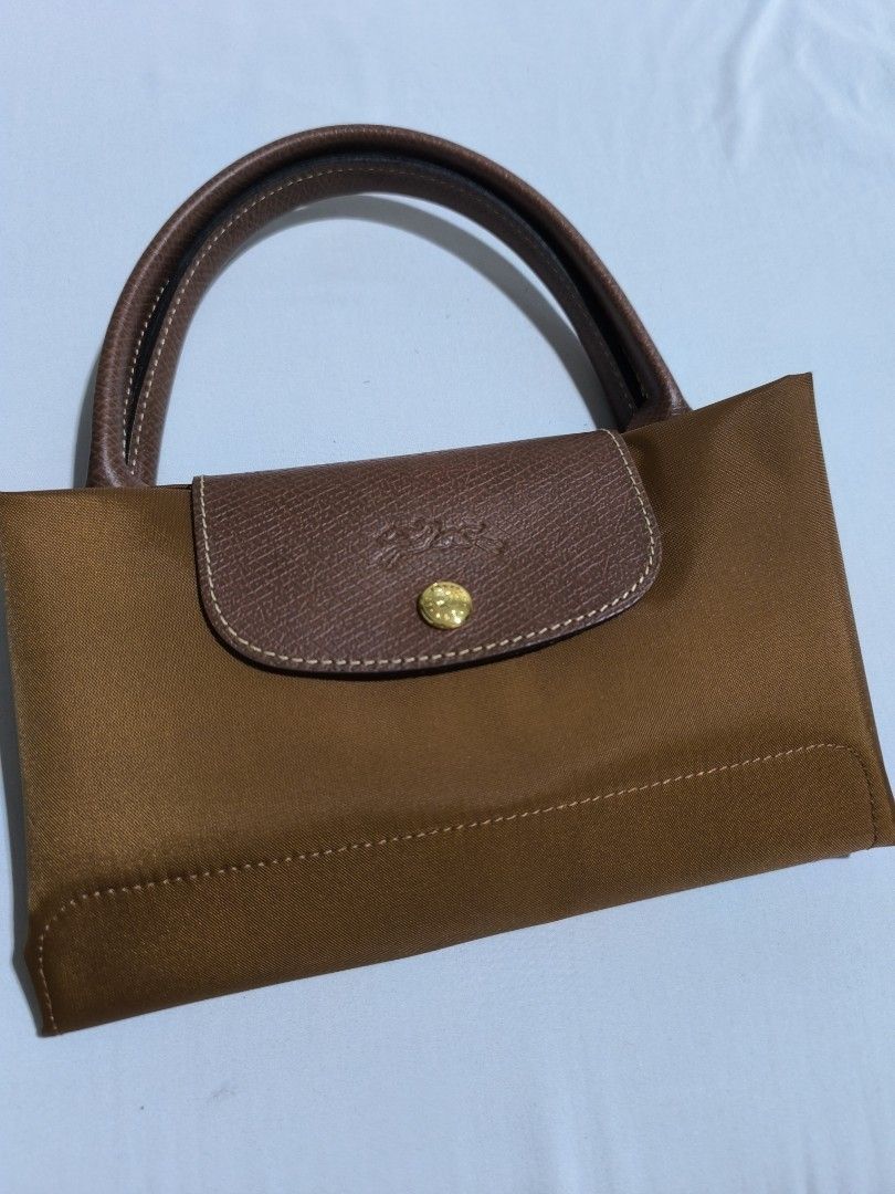 Rustans bought Longchamp Le Pliage Classic Top Handle Medium in Cognac (Category: Luxury Bags & Wallets) located in Manila. Submitted by loveyelenna (Listing ID 1429741026, Image 2). Description: Used once Bought from Rustans Shangri la for 10k - can provide receipt Can video call for details Complete inclusions - care card,plastic pouch, paperbag RFS: I prefer large long handle Note: black photo for size reference only.