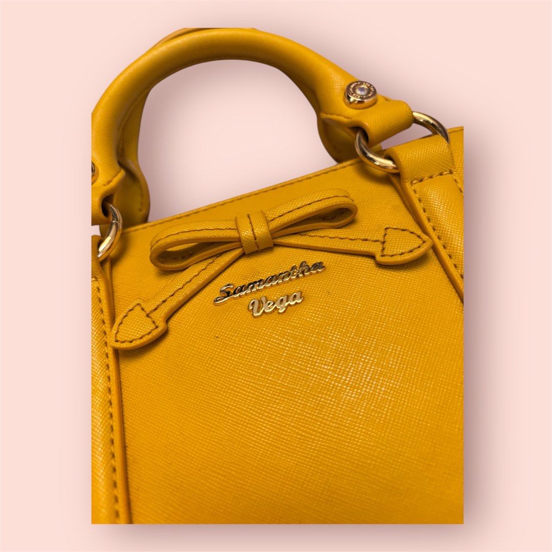 Samantha Vega Yellow Handbag (Category: Luxury Bags & Wallets) located in Rosario. Submitted by preloveditems2002 (Listing ID 1432958413, Image 3). Description: - Samantha Vega handbag - Yellow color - Dome shape - Top handles - Detachable tag - Gold-tone hardware - Bow detail on front - Zipper closure.