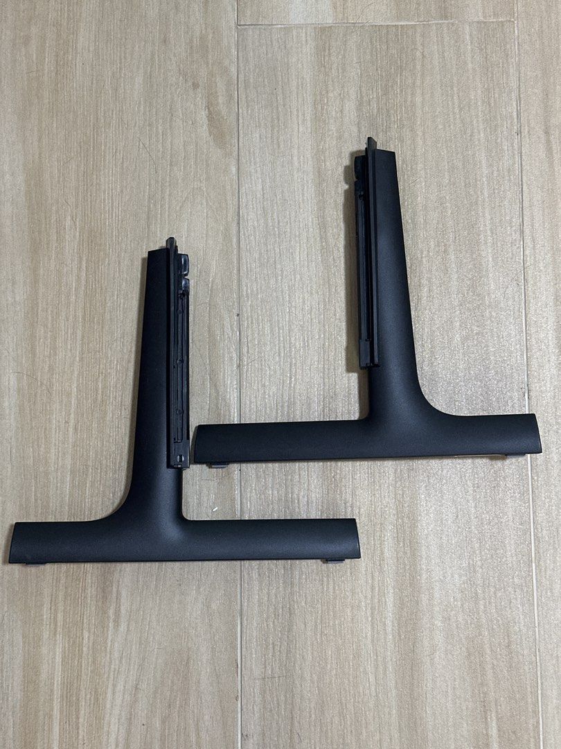 全新原裝Samsung TV Stand （分類：電視組件及配件）位於 Hong Kong。 由 hywwwww 提交（商品編號 1432839689，圖片 1）。簡介： Pair of black Samsung TV stands. The stands have a T-shaped base and a vertical section with a mounting mechanism. The label indicates the material is PP+GF40 and the resin is GS CALTEX. The model number is E119841. The stands are designed to support a Samsung TV.。