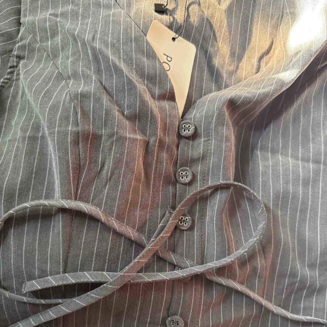 SHEIN Gray Pinstripe Top with Tie S (Category: Sleeveless) located in Legazpi City. Submitted by loveagainz (Listing ID 1432845762, Image 2). Description: - Used once for an event - Gray pinstripe top - V-neck design - Button closure - Tie detail at waist - Short sleeves - Lightweight fabric - Brand new with tag - Perfect for casual or semi-formal occasions.