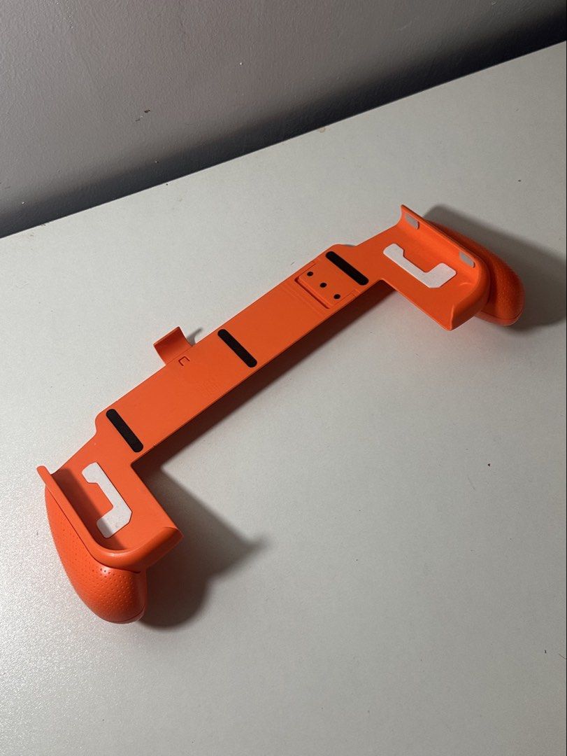 Skull & Co NeoGrip for Nintendo Switch OLED Limited Edition Orange (Category: Controllers) located in Santa Barbara. Submitted by marcaws (Listing ID 1432942172, Image 3). Description: - Fits both Nintendo Switch V1 and OLED. - No box. Item only. - Comfortable and ergonomic grip design. - Slim design and lightweight material. - 1000 units are sold only (limited edition) - Includes a secure clip to hold your Switch. - Enhances your gaming experien