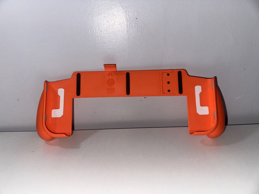Skull & Co NeoGrip for Nintendo Switch OLED Limited Edition Orange (Category: Controllers) located in Santa Barbara. Submitted by marcaws (Listing ID 1432942172, Image 2). Description: - Fits both Nintendo Switch V1 and OLED. - No box. Item only. - Comfortable and ergonomic grip design. - Slim design and lightweight material. - 1000 units are sold only (limited edition) - Includes a secure clip to hold your Switch. - Enhances your gaming experien