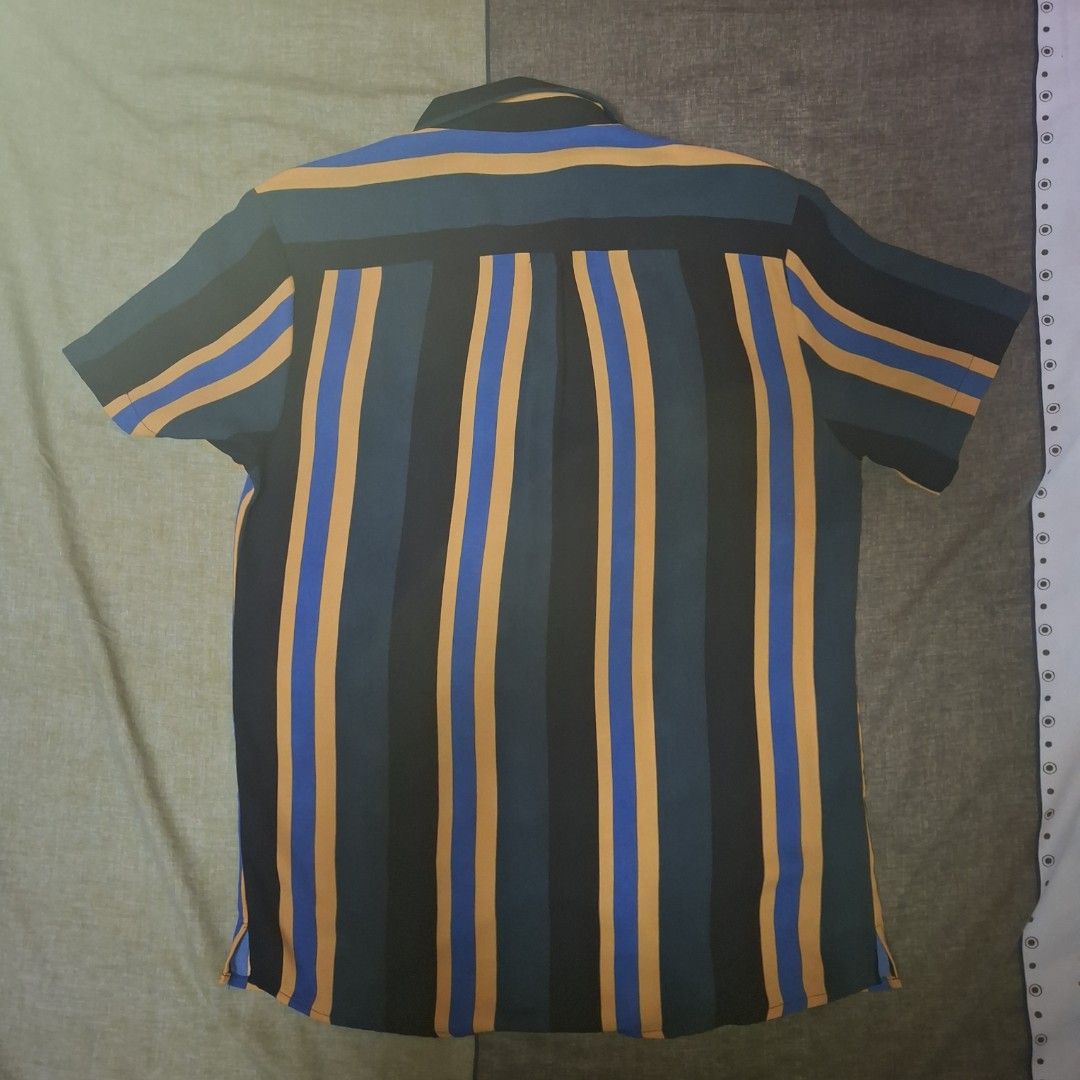 Smyth Striped Short Sleeve Shirt (Category: Tshirts & Polo Shirts ) located in Manila. Submitted by thealmightyone (Listing ID 1432952755, Image 2). Description: - Smyth striped shirt - Collared neckline - Short sleeves - Button-down closure - Regular fit - Color scheme: Teal, black, blue, and yellow stripes - Brand tag present.