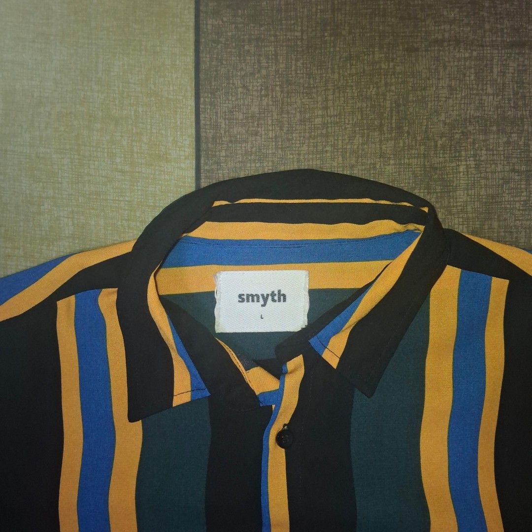 Smyth Striped Short Sleeve Shirt (Category: Tshirts & Polo Shirts ) located in Manila. Submitted by thealmightyone (Listing ID 1432952755, Image 3). Description: - Smyth striped shirt - Collared neckline - Short sleeves - Button-down closure - Regular fit - Color scheme: Teal, black, blue, and yellow stripes - Brand tag present.