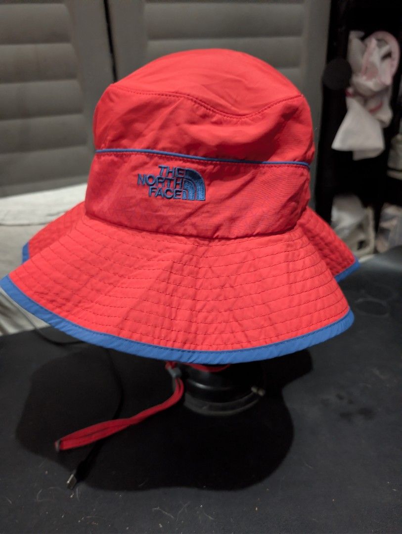 The North Face Reversible Bucket Hat (Category: Caps & Hats) located in Imus. Submitted by kmoort (Listing ID 1432846456, Image 1). Description: - The North Face reversible bucket hat - Vibrant red and blue color scheme - Red exterior with blue brim - Blue interior - Includes a chin strap - Features snap buttons - Embroidered The North Face logo - Made of lightweight, possibly water-resistant material -medium on tag .