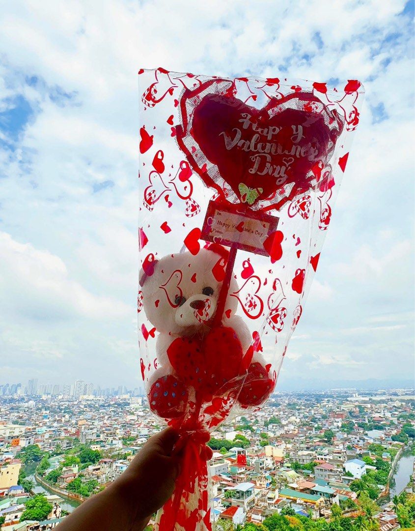Valentine's Day Teddy Bear Bouquet (Category: Flowers & Bouquets) located in Taguig. Submitted by seek_and_ship (Listing ID 1432969623, Image 3). Description: - Adorable teddy bear bouquet for Valentine's Day. - Features a cute plush teddy bear holding a "Happy Valentine's Day" sign. - Beautifully wrapped in clear cellophane with heart patterns. - Tied with a festive red ribbon. - Includes a heart-shaped balloon. - A perfect and heartwarming gift
