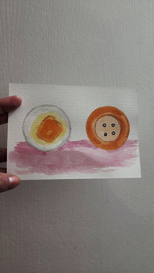 Watercolor Painting - Egg and Button (Category: Art & Prints) located in Cavite. Submitted by joycreates (Listing ID 1432950621, Image 2). Description: - Original watercolor painting - Subject: Halved egg and button - Painted on paper with a pink wash - Artist's signature visible - Unframed - Unique artwork for your collection.