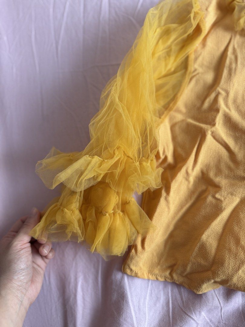 Yellow Ruffle Sleeve Blouse (Category: Blouses) located in Manila. Submitted by aimelamode (Listing ID 1432877080, Image 2). Description: Bought in BKK. Yellow blouse with ruffle sleeves. Features a collared neckline and button-down front. Elegant sheer sleeves and textured material..