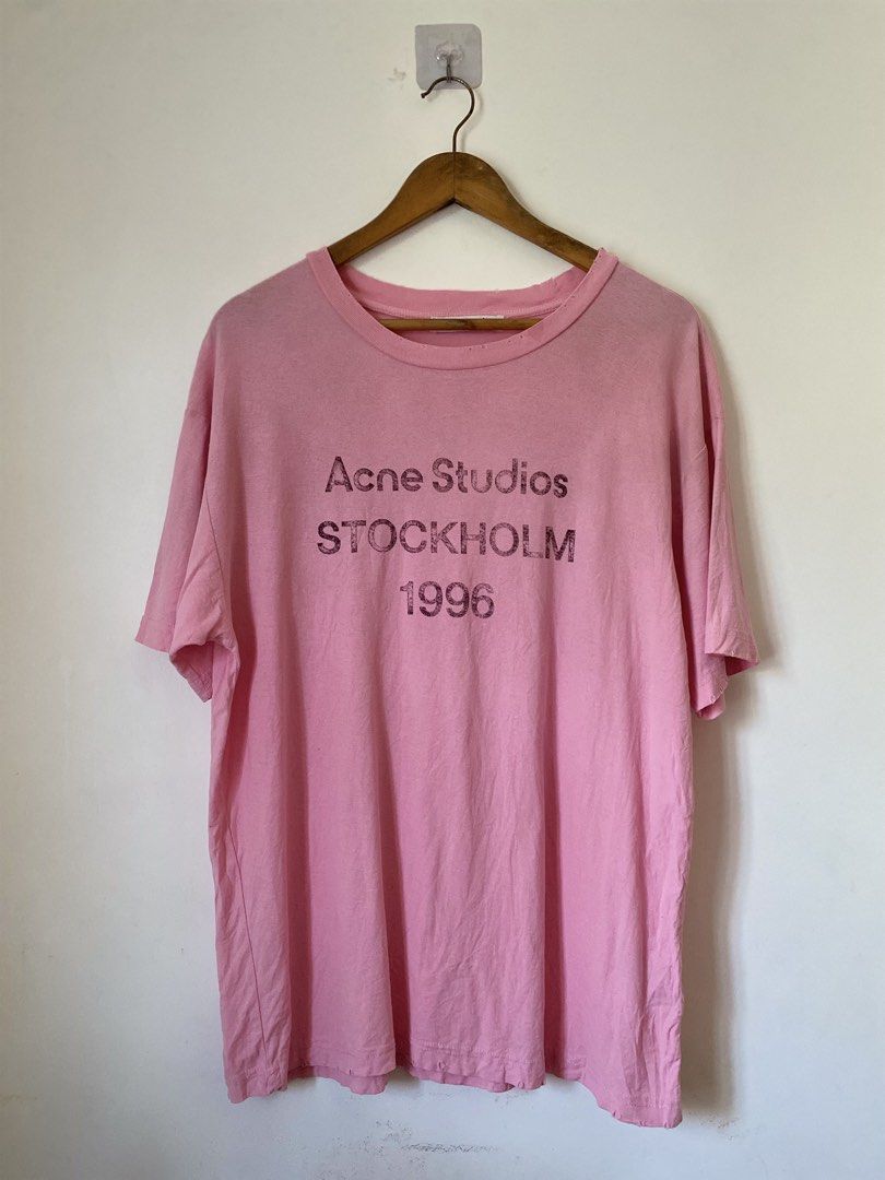Acne Studios Stockholm 1996 Distress Pink T-shirt (Category: Luxury Apparel) located in Binmaley. Submitted by maryjeyn (Listing ID 1433033321, Image 1). Description: - Acne Studios T-shirt - Color: Pink - Print: "Acne Studios Stockholm 1996" - Size: XS - Made in Portugal - Material: 100% Cotton - Features: Crew neck, short sleeves and distress Tee.