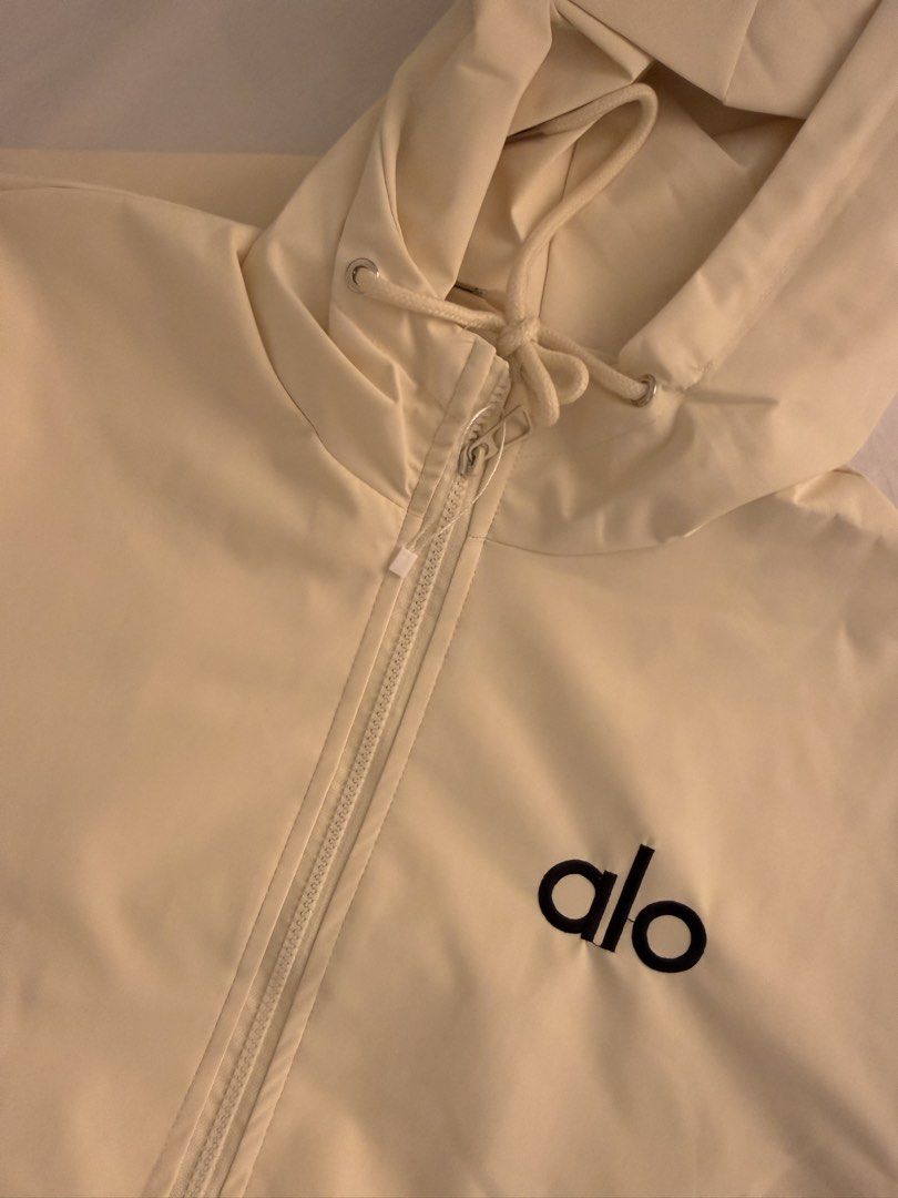 Alo Cream Jacket with Hood (Category: Coats, Jackets and Outerwear) located in Quezon City. Submitted by mochiringo84 (Listing ID 1433037378, Image 1). Description: - Cream-colored Alo jacket - Hooded with zipper closure - Features the Alo logo - Two side pockets - Elastic cuffs on sleeves - Made of lightweight material.